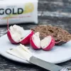 Vegan Gold butter alternative by mouses favourite with packet in background and some spread on radishes in the front - a typical French rustic dish