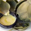 Vegan Gold butter alternative by mouses favourite melted and used as a dip for a freshly cooked globe artichoke.